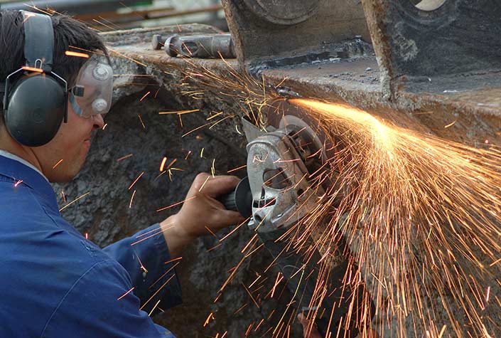 Mann sägt Metall mit Winkelschleifer